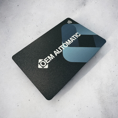 Digital Business Card with 'OEM Automatic' logo on a gray surface